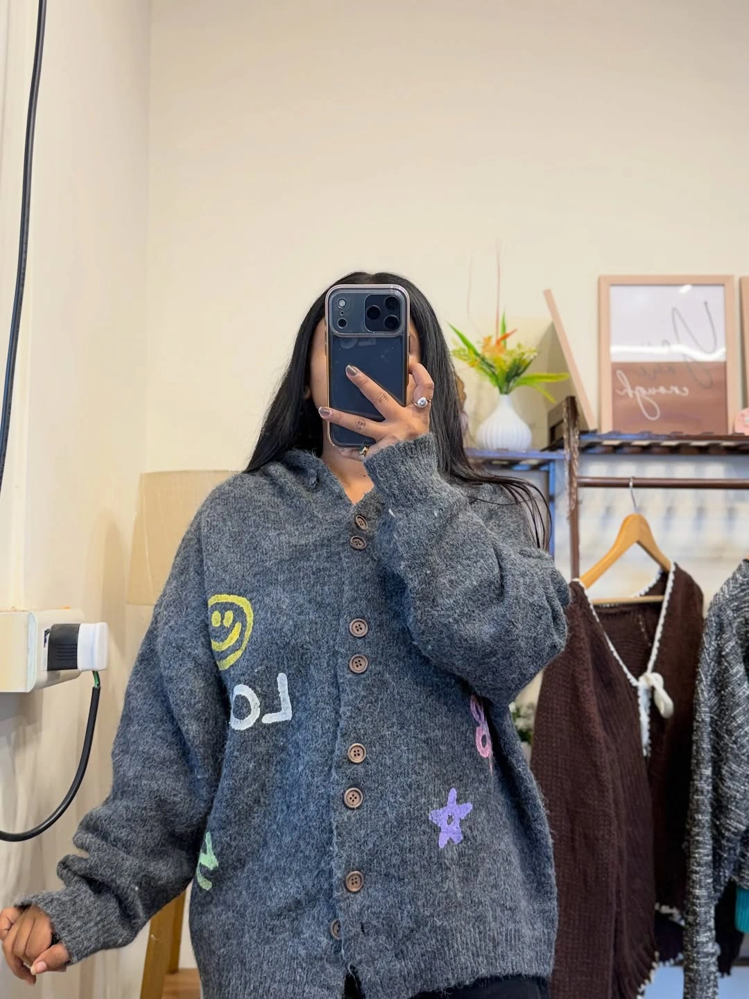 Oversized blue-gray buttoned cardigan with colorful motifs, lettering, and star shapes