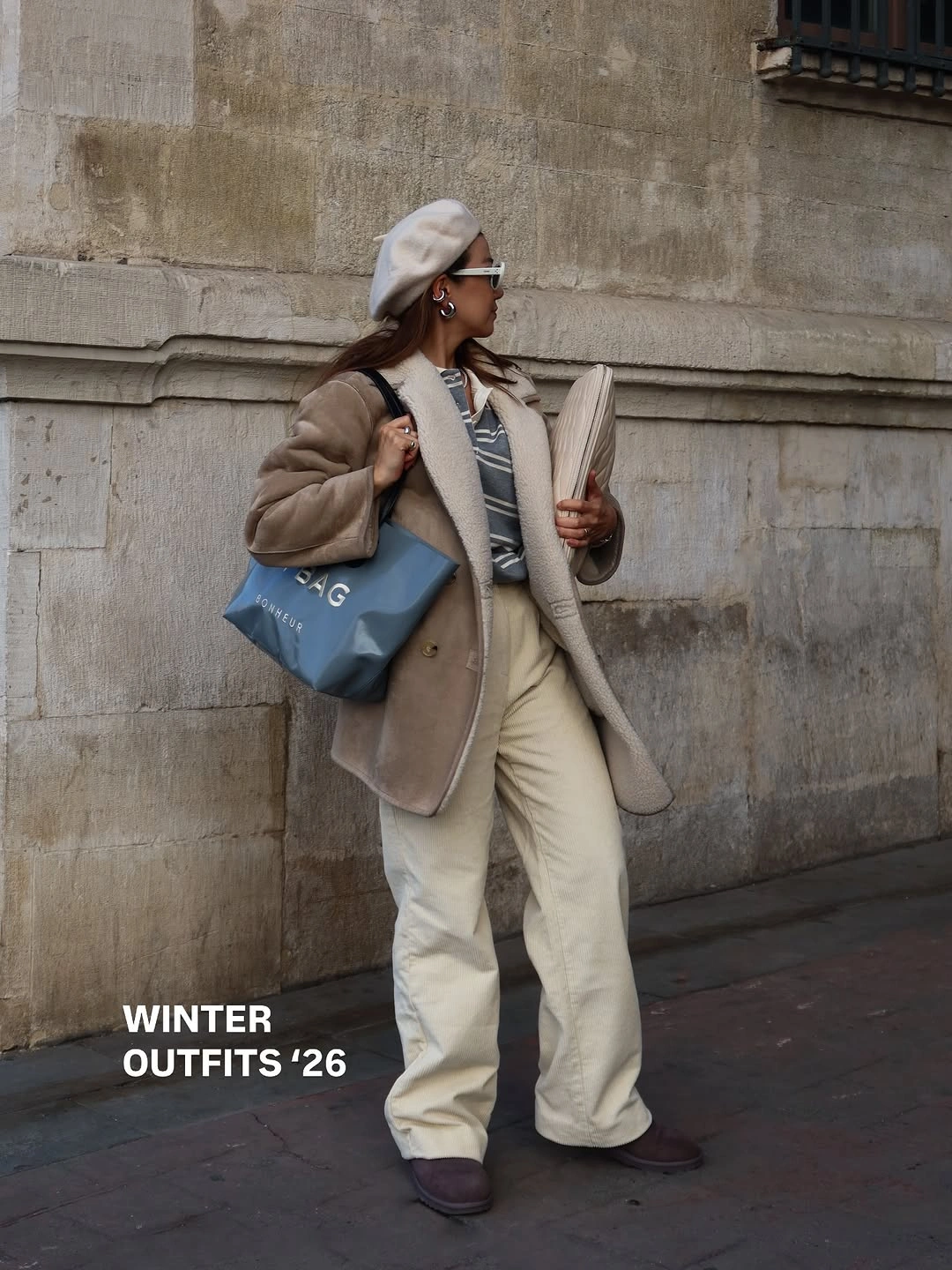 Oversized taupe jacket, wide cream trousers, pale beret, and blue handbag