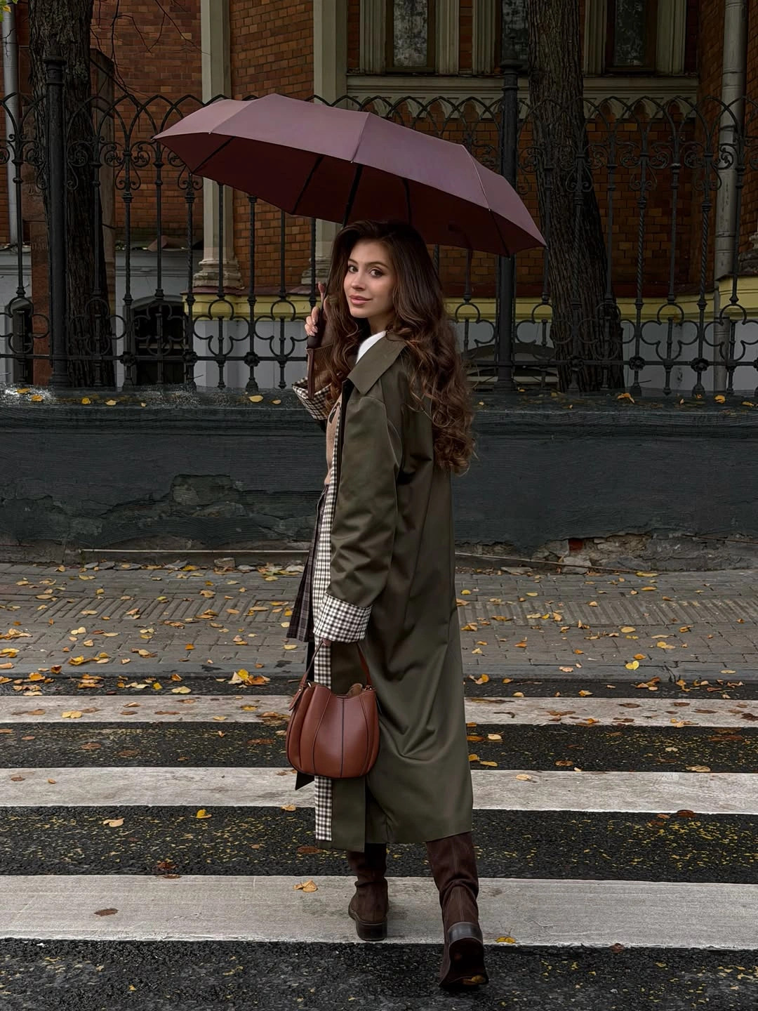 Long olive green coat checked layer brown boots and burgundy umbrella