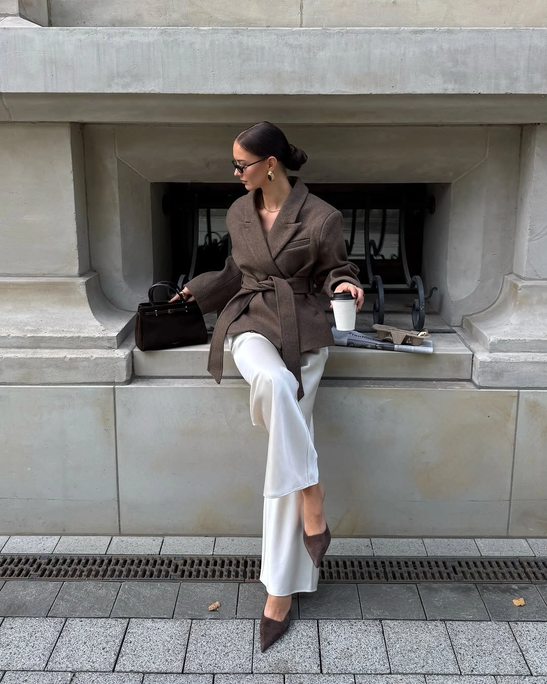 Brown belted wrap jacket white wide-leg trousers and pointed heels