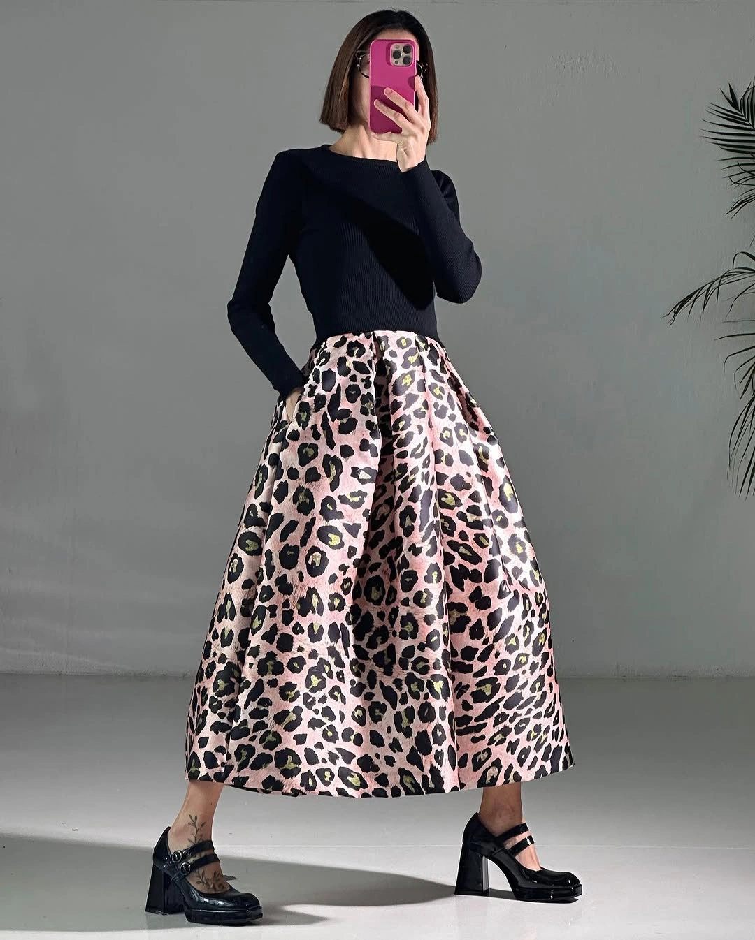 Fitted black long-sleeve top full leopard print skirt and strapped heels