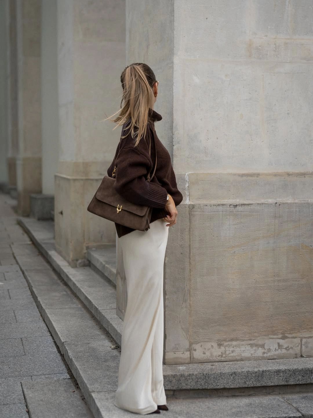 Dark brown sweater with long ivory lower silhouette and brown shoulder bag