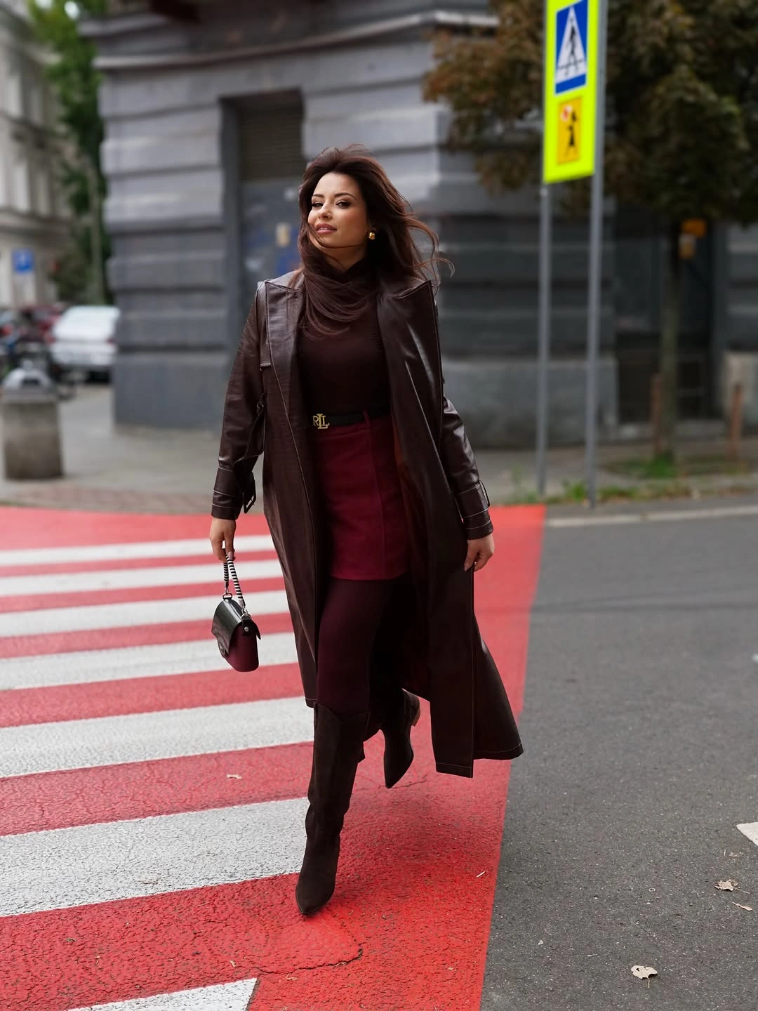 Long dark brown coat burgundy skirt dark tights and pointed boots