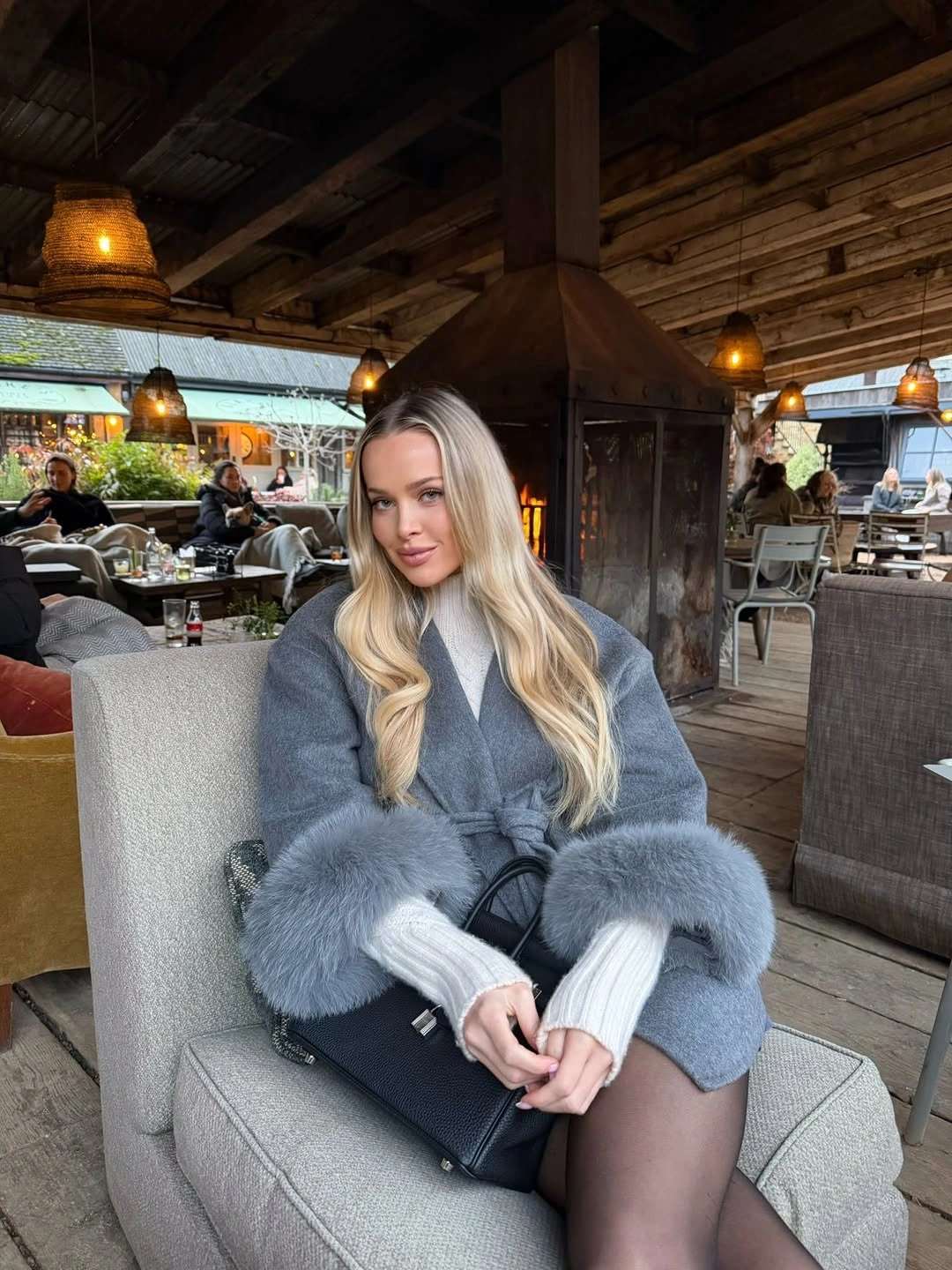 Gray jacket with oversized fluffy cuffs pale ribbed sleeves and black handbag